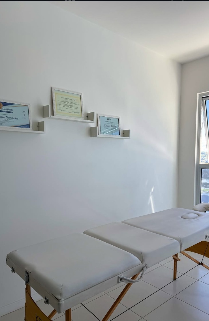 Sala de atendimento com maca e certificados